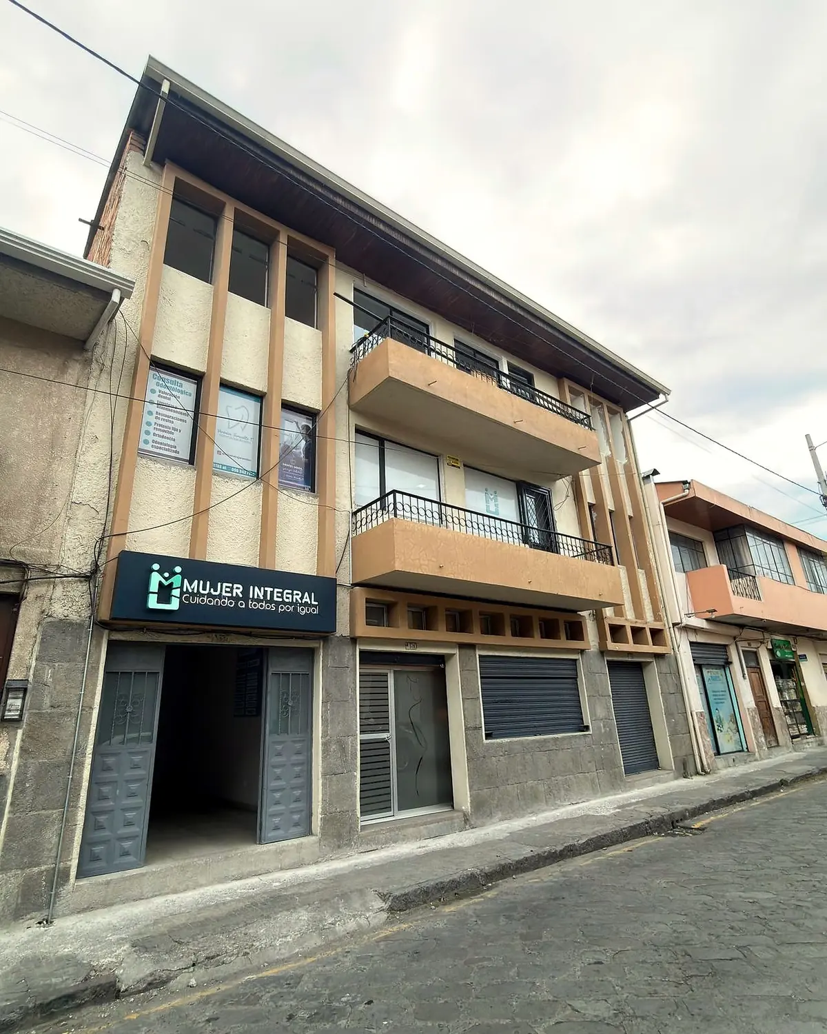 Fachada del Centro Médico Mujer Integral: edificio de tres pisos con paneles verticales de madera y el rótulo Mujer Integral