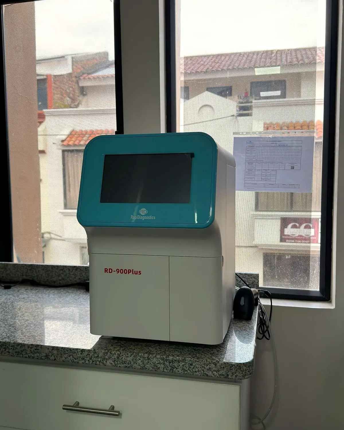 Analizador de pantalla táctil sobre la mesada del laboratorio, junto a la ventana