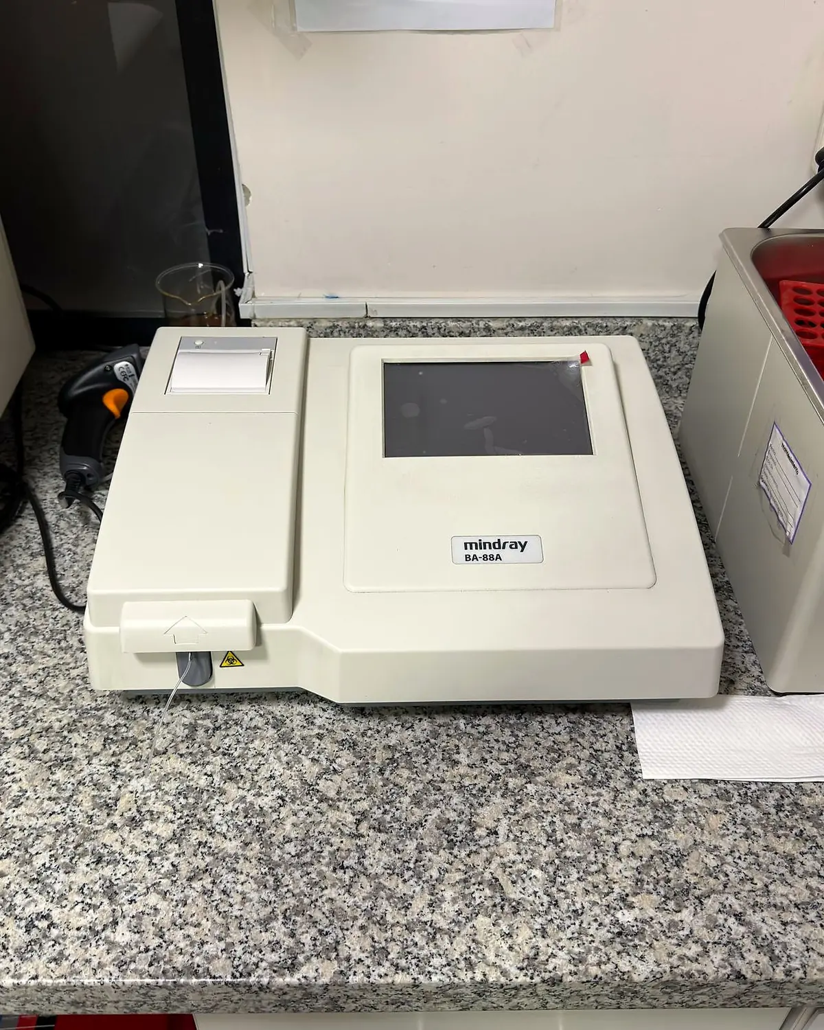 Analizador semiautomático con impresora junto a una centrífuga