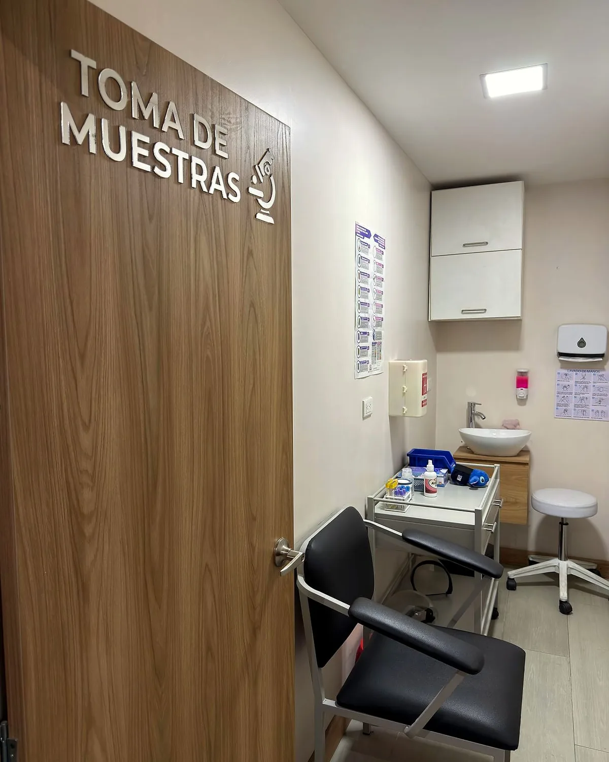 Puerta de madera rotulada TOMA DE MUESTRAS y sillón de extracción