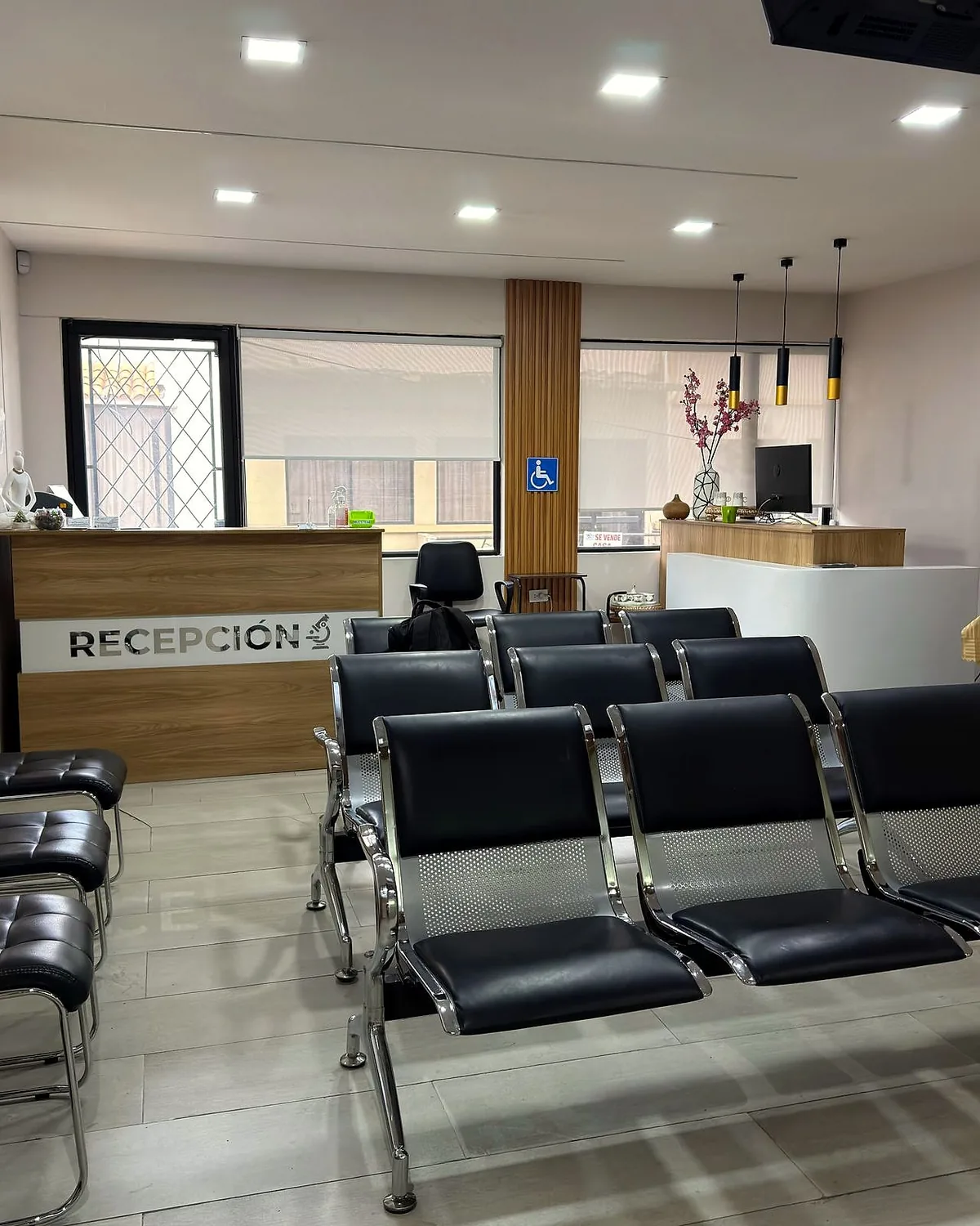 Recepción de planta baja con el mostrador rotulado RECEPCIÓN y la sala de espera