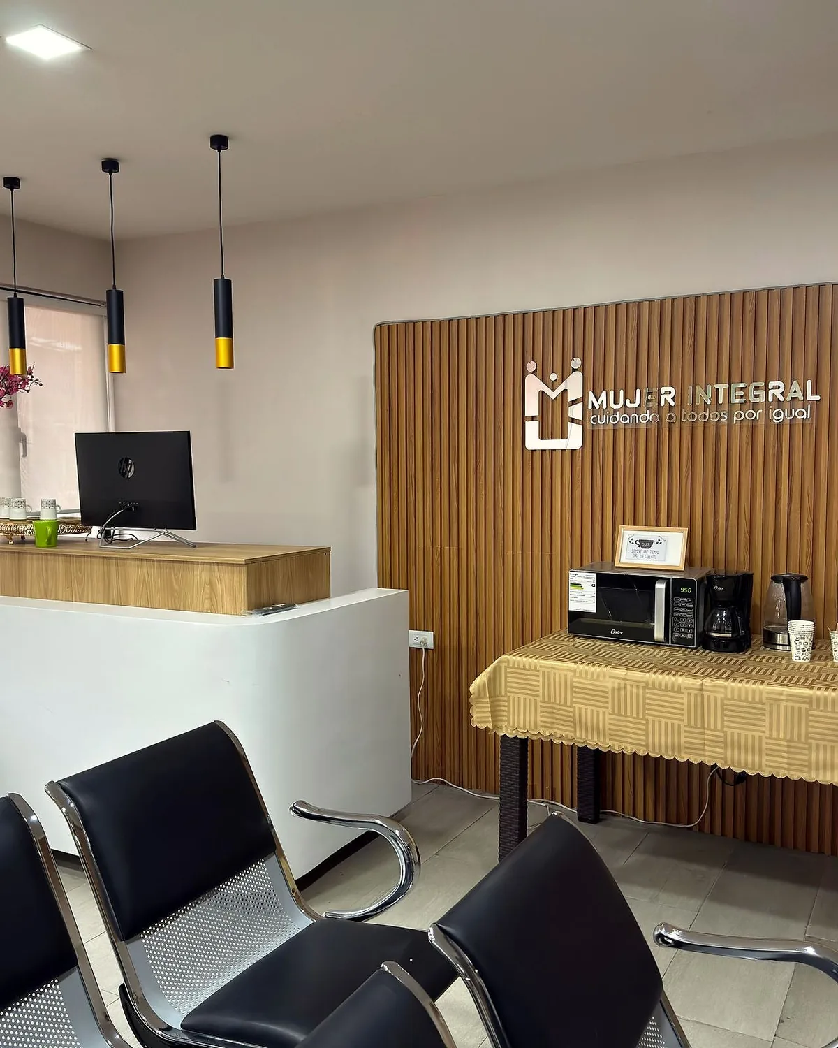 Recepción del laboratorio con el logotipo Mujer Integral sobre un panel de madera