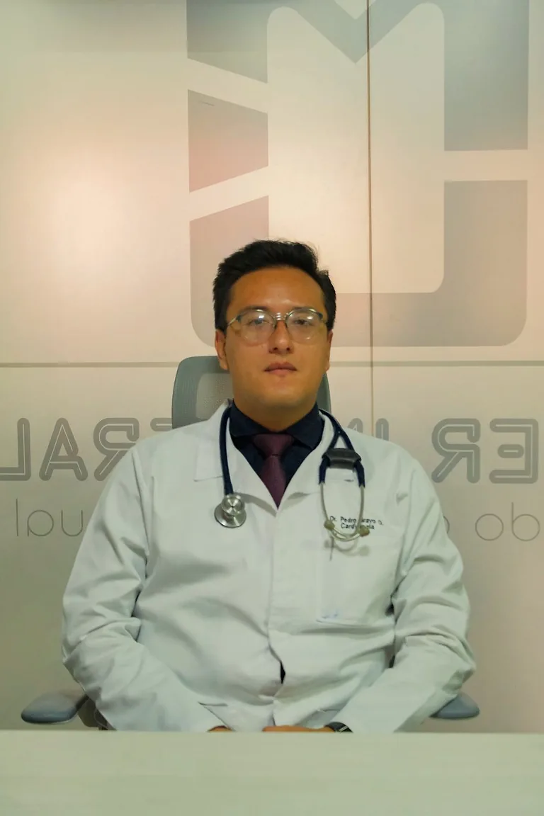 Dr. Pedro Ojeda con el estetoscopio, sentado en su consultorio